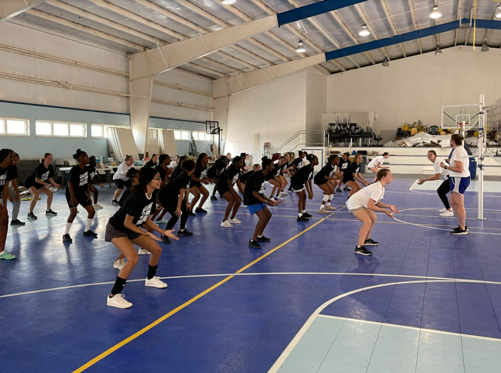 Students in a gymnasium learning the proper stances for volleyball