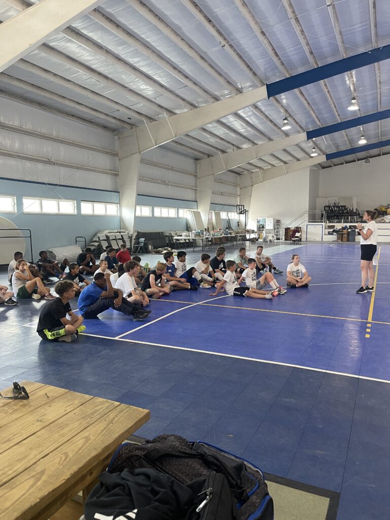 The volleyball coach giving a lesson during volleyball camp to the boy section