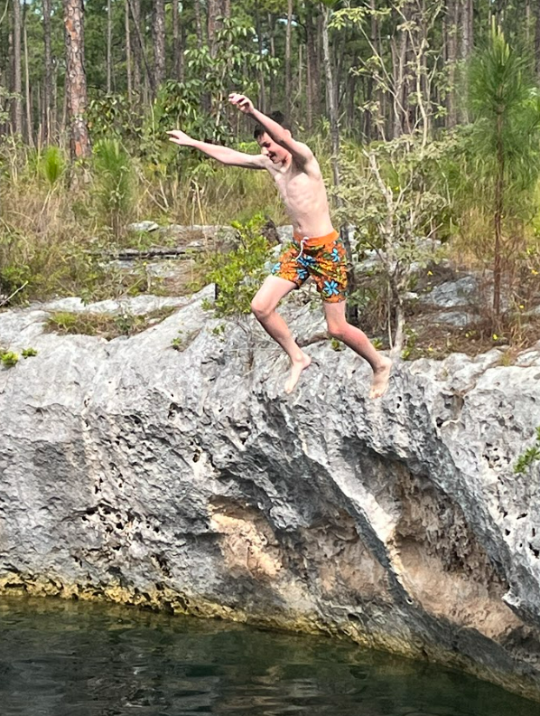 A team member jumping into a blue hole