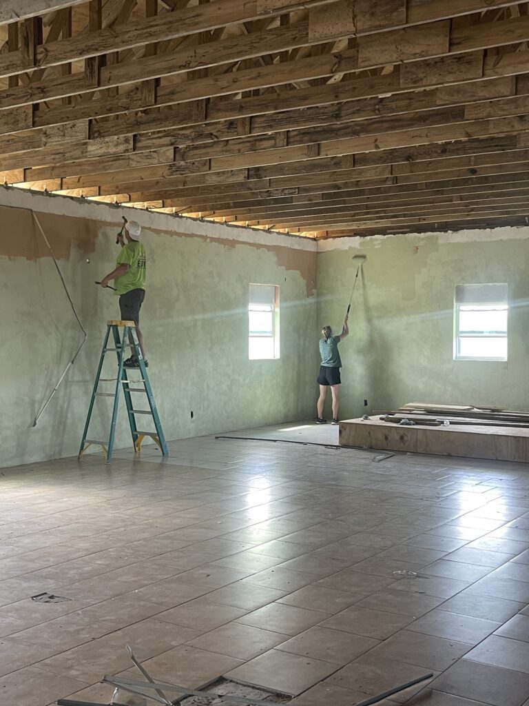 Two team members priming the inside of the community center