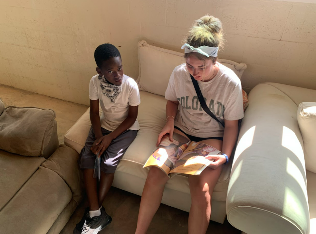 One team member reading to a student at Camp Abaco.