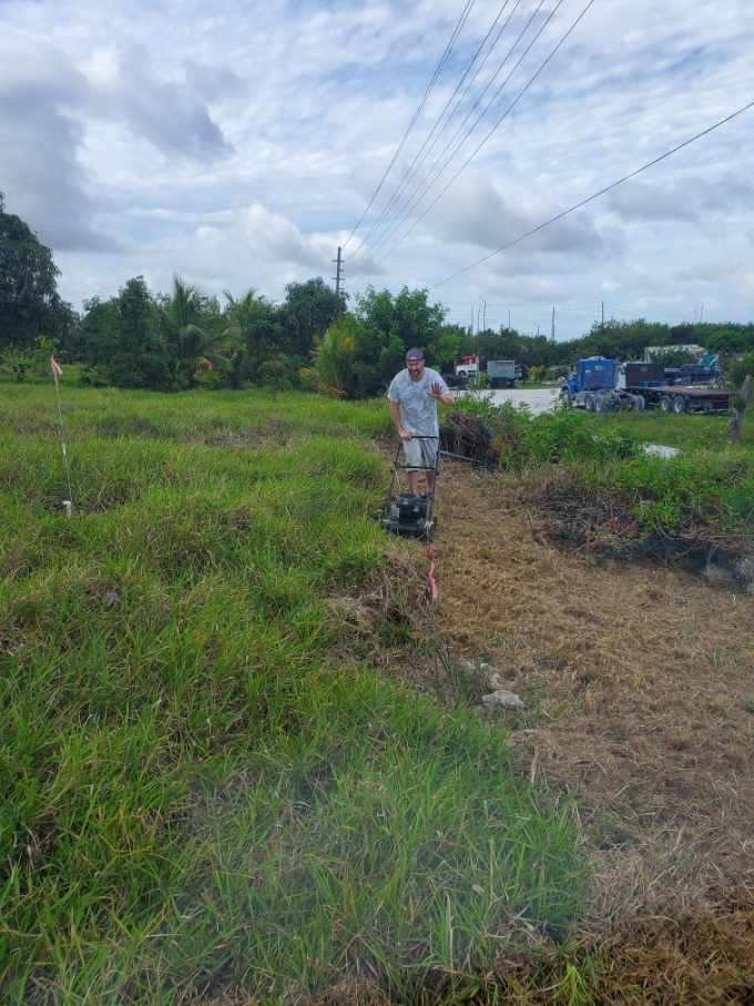 A team member mowing a very overgrown area