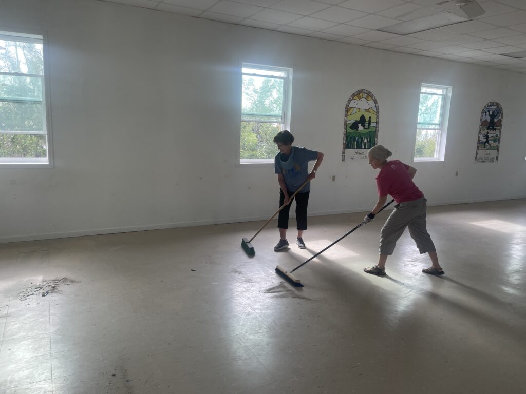 Team members sweeping the floor in the chapel