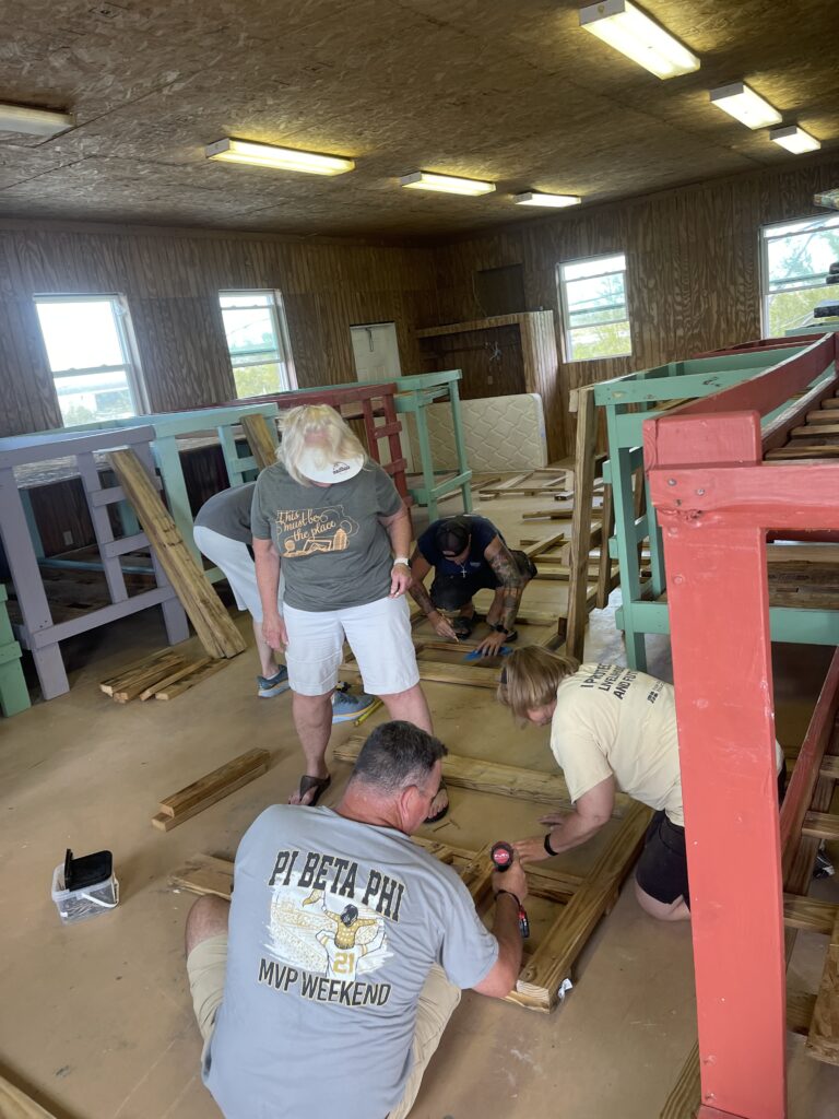 Men and women screwing bunk bed pieces together